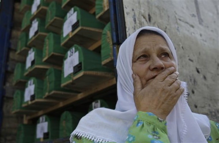 Bosnian Muslim woman Hamida Avdic stands near one of three trucks loaded with caskets of Srebrenica massacre victims, near Visoko city morgue, Bosnia, on Saturday.